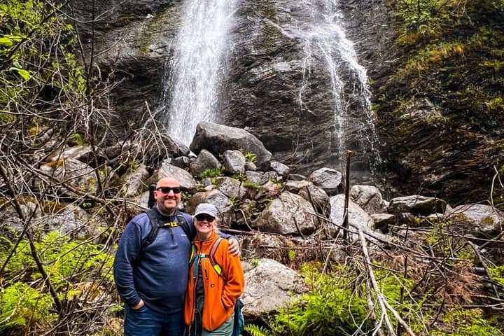 a person standing next to a waterfall